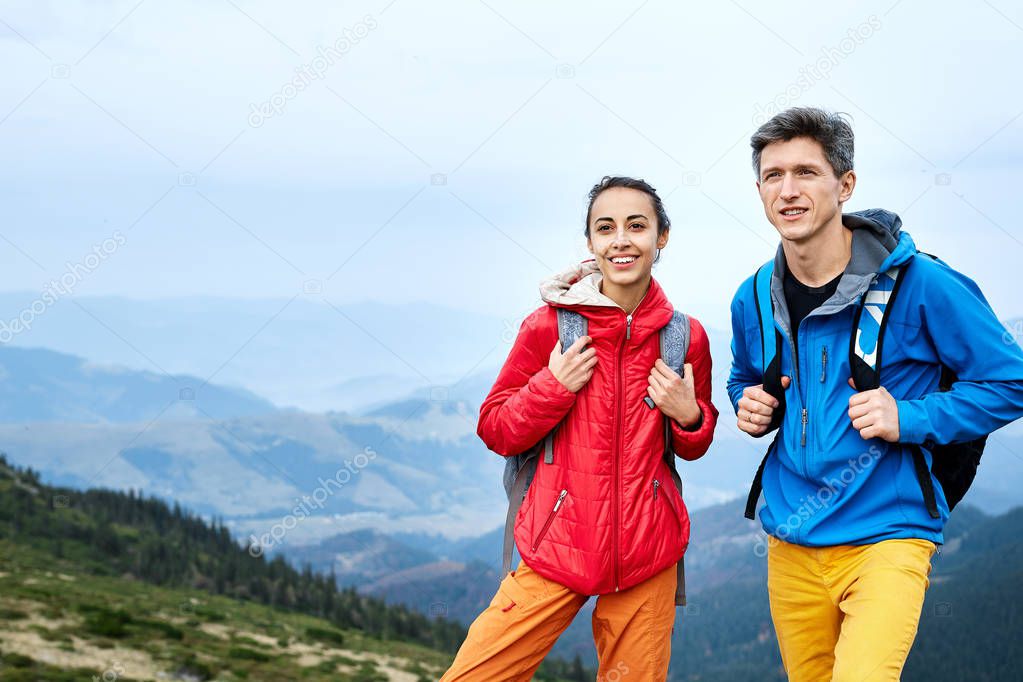 couple tourists standing on the mountains background