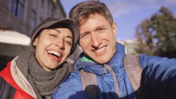 Zamilované do pár objímání, líbání a dělá selfie během procházky městem — Stock video