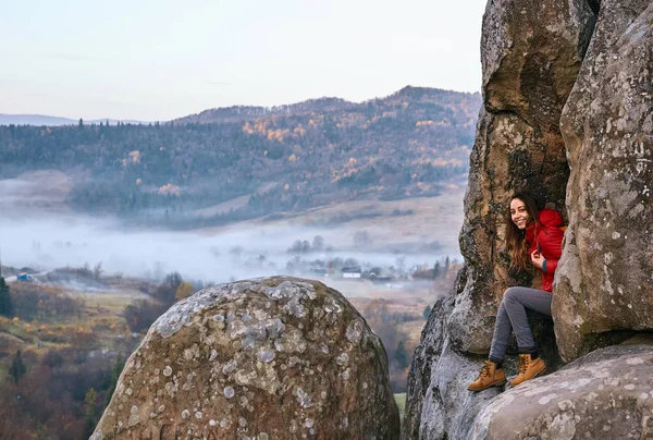 Жінка сидить на краю скелі на фоні долини — стокове фото