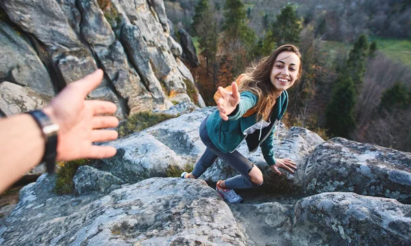 Woman hiker climbed on the cliff and getting help — Stock Photo, Image