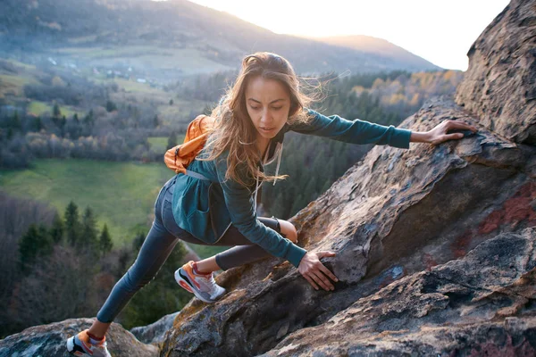 Woman hiker climbed on the cliff and looks confused — Stock Photo, Image