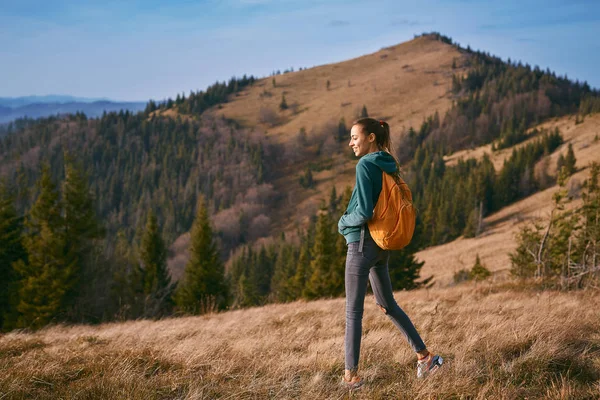 Immagine di donna felice escursionista in piedi sul bordo della cresta di montagna sullo sfondo del tramonto — Foto Stock