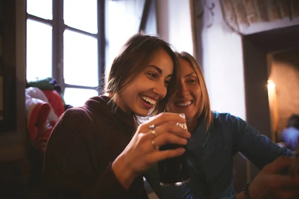 Två väninnor sitter i puben med glas öl — Stockfoto