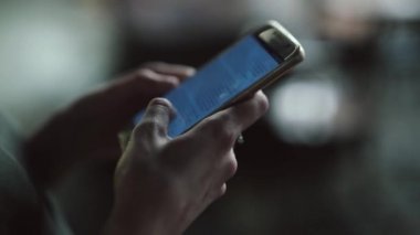 genç kadın telefonu kullanarak şehirde geceleri açık havada duruyor.