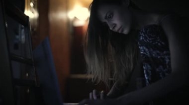çekici genç kadın karanlık odada oturan ve laptop arıyorum