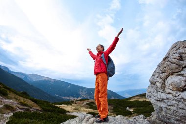 gündoğumu arka plana karşı uçurumun kenarında duran kadın