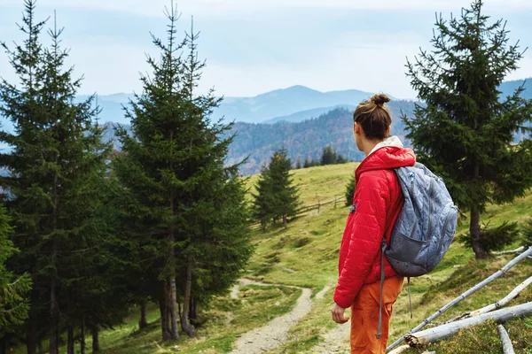 Mujer excursionista con mochila caminando al aire libre en las montañas —  Fotos de Stock