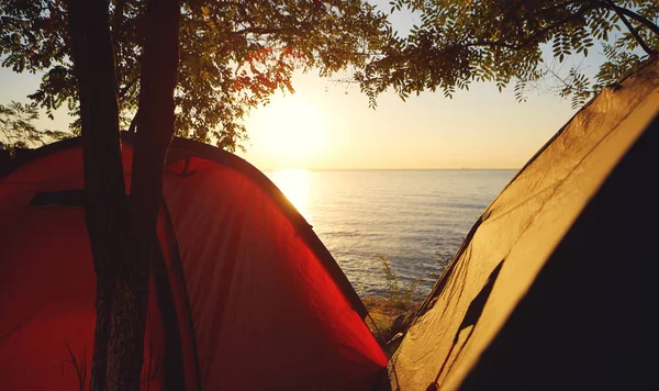 Две палатки на берегу моря на фоне заката . — стоковое фото