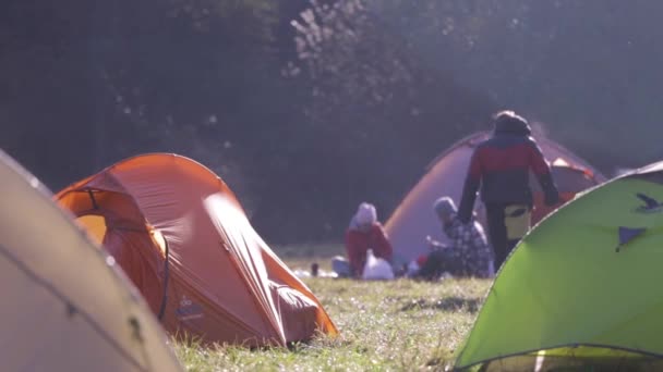 Campsite with tents on a green grass in the forest in fall at foggy morning. Autumn weekend forest hiking with tents. — Stock Video