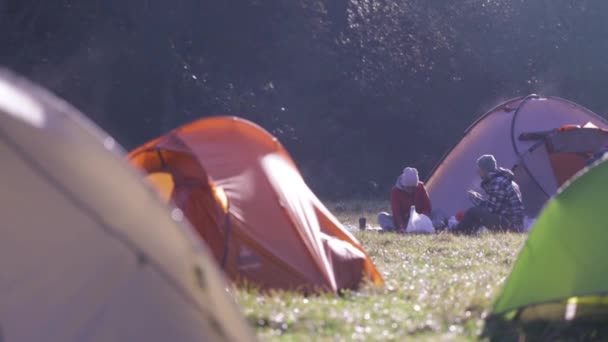 Campsite with tents on a green grass in the forest in fall at foggy morning. Autumn weekend forest hiking with tents. — Stock Video