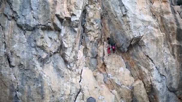 Man klimmer klimmen op de klif in de winter. rotsklimmen. man rock klimmer het beklimmen van de uitdagende route op de kalkstenen muur — Stockvideo