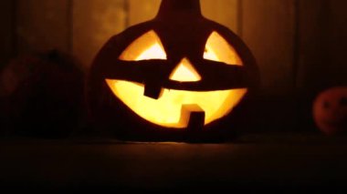 Ahşap arka planda Cadılar Bayramı kabak kafa jakı fener. Cadılar Bayramı sembolü olarak korkutucu yüzü ile oyulmuş kabak.