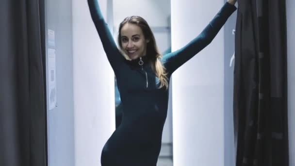 Eine junge Frau probiert in der Umkleidekabine des Ladens ein schönes sexy Kleid an — Stockvideo