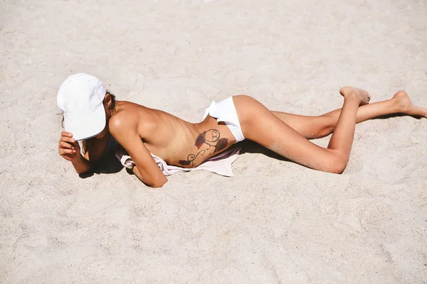 Draufsicht auf die schöne athletische Frau, die sich im Sommer im Bikini am Sandstrand bräunt. Sommerferienkonzept. — Stockfoto
