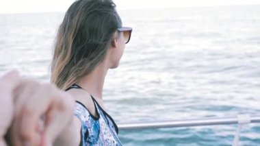 deniz arka planda hafif yaz elbise ve güneş gözlüğü genç güzel bir kadının ilk kişi görünümü. Genç güzel gülümseyen kadın rıhtımda açık havada poz elinde bazı bir tutan