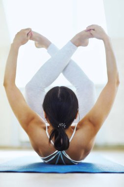 Beyaz spor jimnastik salonu beyaz duvar arka plan ile bir spor salonunda poz güzel yoga yaparken Genç sporla kadın arka görünümü. Sağlıklı yaşam tarzı, sabah egzersizleri, meditasyon.