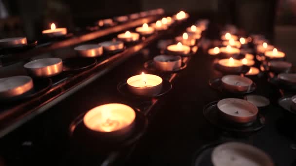 Zapalony świece w świątyni w zmierzchu. Płonące świece kościelne — Wideo stockowe