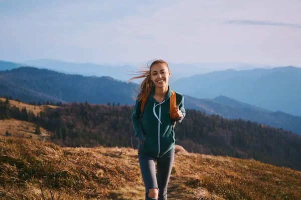 Muotokuva onnellinen nainen patikoija seisoo reunalla vuoren harjanteella. Matkailu ja aktiivinen elämäntapa . — kuvapankkivalokuva