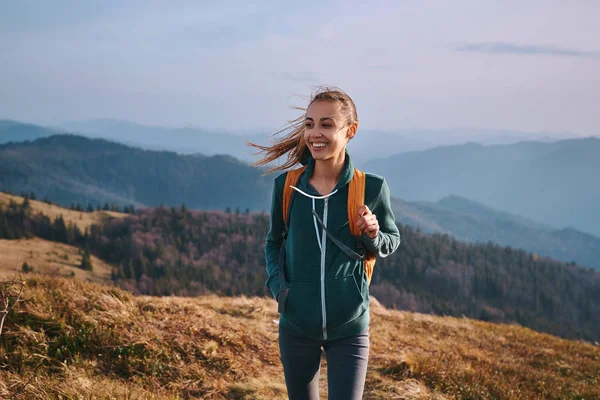 Portrett av lykkelig kvinnelig fotturist som står på kanten av fjellryggen. Reise og aktiv livsstil . – stockfoto