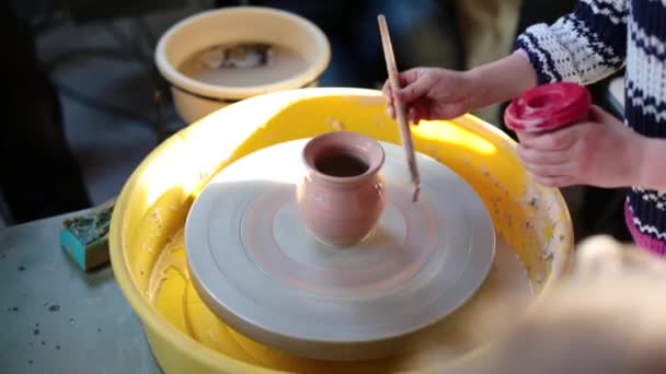 Rueda de alfareros en el taller de cerámica. Artesanía Cerámica dentro. niños Manos trabajando en una rueda de cerámica, formando una olla de barro . — Vídeo de stock