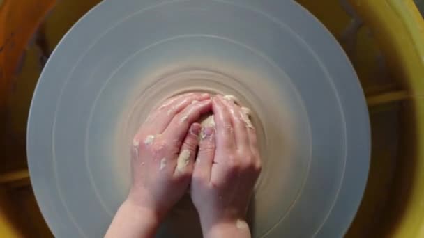 Krukmakare rullar i keramikverkstaden. Hantverk keramik inuti. barn händer som arbetar på keramik hjul, forma en lerkruka. — Stockvideo
