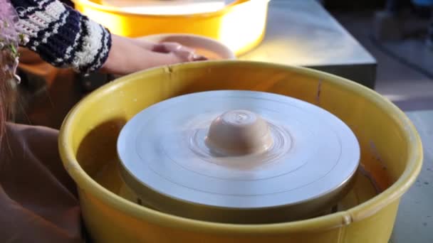 Rueda de alfareros en el taller de cerámica. Artesanía Cerámica dentro. niños Manos trabajando en una rueda de cerámica, formando una olla de barro . — Vídeo de stock