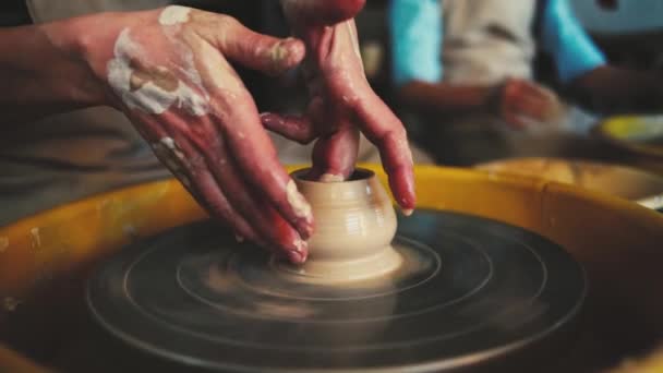 Oleiros roda na oficina de cerâmica. Olaria artesanal dentro. womans Mãos trabalhando na roda de cerâmica, moldando um pote de barro . — Vídeo de Stock
