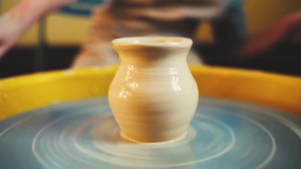 Krukmakare hjulet i keramikverkstad. Hantverk keramik inuti. barnhänder arbetar på keramik hjulet, forma en lervas. — Stockvideo