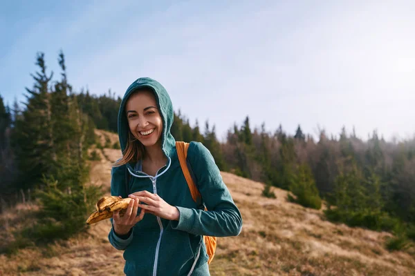 Portrait of happy woman hiker in the hood standing on edge of mountain ridge. Travel and active lifestyle concept. — Stock Photo, Image