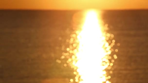 Wschód słońca nad spokojnym morzem. Słońce wschodzi tuż nad morzem i duży piękny promień odbija się na powierzchni wody — Wideo stockowe