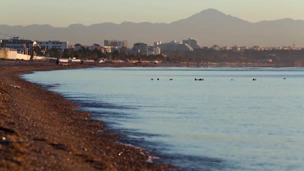 Blick auf den öffentlichen Strand und das ruhige Meer beim Sonnenaufgang in Antalya, Türkei. — Stockvideo