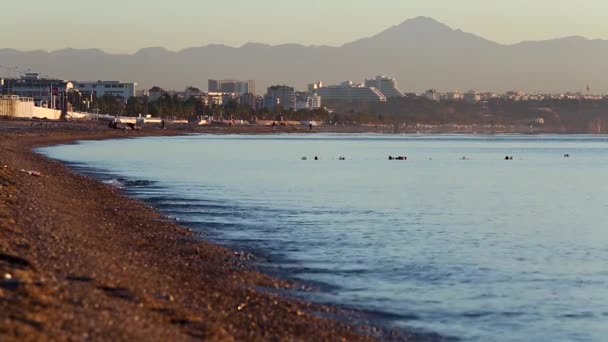 Vue sur la plage publique et la mer calme au lever du soleil à Antalya, Turquie . — Video
