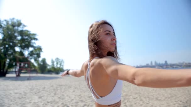 Venkovní portrét mladé, štíhlé atletické ženy, stojící v Jóga Asana s zdviženou rukou na městě a na pozadí modrého nebe. mladá fitness dáma smíšená rasa asijské kavkazské etnického původu na — Stock video