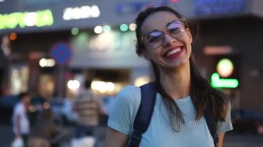 Açık havada gece şehir ışıkları arka planda sokakta açık havada poz, Gözlük Genç bir yetişkin güzel kadın kentsel portre. yaz akşamı modern genç kadın yürüyüş şehir