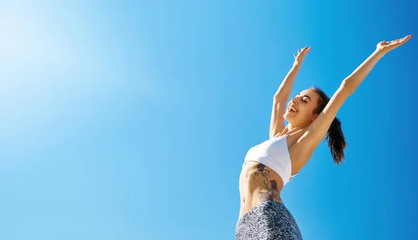 Happy smiling woman with tanned slim body and tattoo posing against blue sky at hot sunny summer day. — Stock Photo, Image