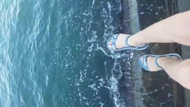 在凉鞋的妇女腿视图，从码头悬挂到大海 — 图库视频影像