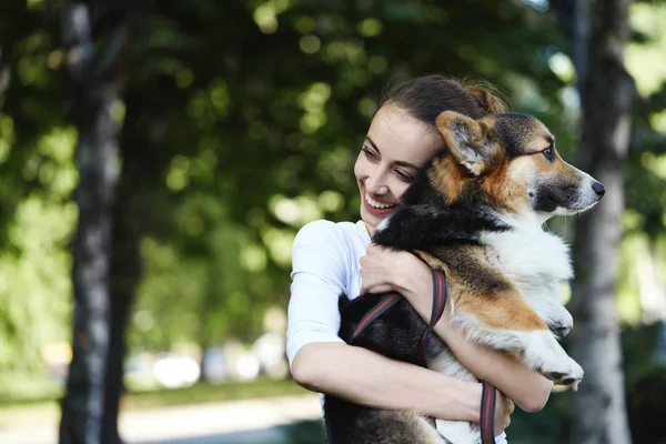 Welsh Corgi Pembroke สุนัขและยิ้ม ผู้หญิงมีความสุขร่วมกันในสวนสาธารณะกลางแจ้ง . — ภาพถ่ายสต็อก