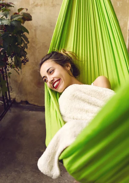 Onnellinen nuori nainen rentouttava riippumatossa terassitalolla . — kuvapankkivalokuva