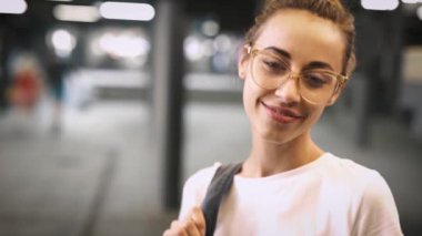 şeffaf gözlük açık havada poz genç gülümseyen şık güzel kadın portresi. yavaş çekim