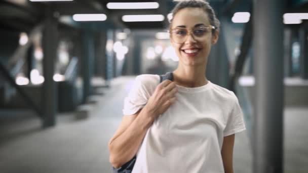 Porträtt av unga leende fashionabla vacker kvinna i transparenta glasögon poserar utomhus. Slow motion — Stockvideo