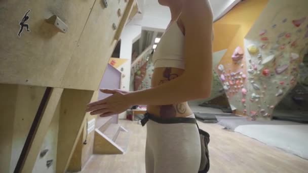 Kobieta wspinaczka jest kredą ręce z białą kredą proszku przed wspinaczką w sali gimnastycznej. kobieta przygotowuje się do wspinaczki. — Wideo stockowe