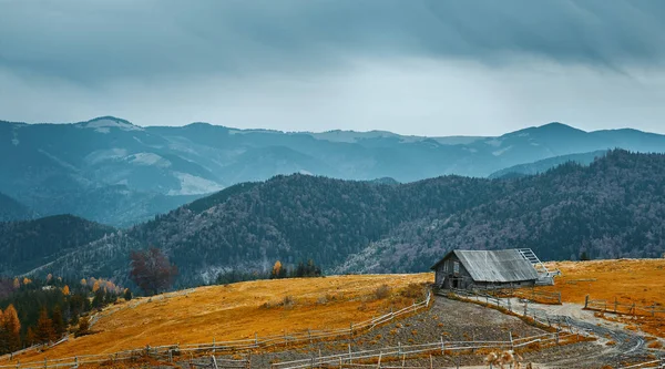 Nádherný výhled na podzimní horskou krajinu s oblačnou oblohou a hospodářstvím — Stock fotografie