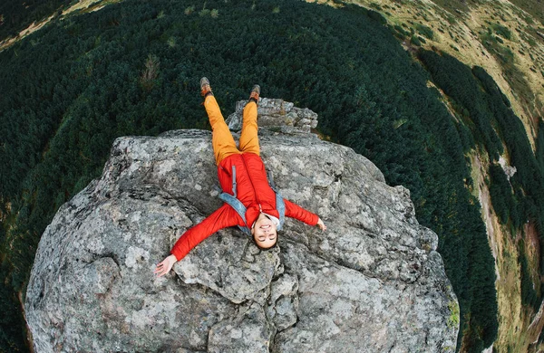 Turista mulher sentada no penhasco nas montanhas — Fotografia de Stock