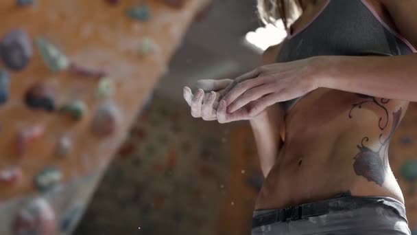 Silhouette of fit slender Woman climber chalking hands and blowing chalk from fingers before climb in indoor climbing gym. athletic muscular woman with good ABS and naked torso getting ready to — Stock Video