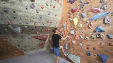 Yetişkin adam Rock dağcı Inside tırmanma Spor Salonu'nda Tırmanıyor. Kapalı Tırmanma Spor Salonu Duvar at Egzersiz adam