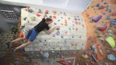 Yetişkin adam Rock dağcı Inside tırmanma Spor Salonu'nda Tırmanıyor. Kapalı Tırmanma Spor Salonu Duvar at Egzersiz adam