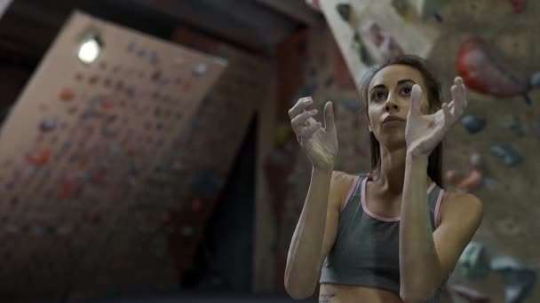 Fit delgado cansado Mulher alpinista com bom ABS e tronco nu descansando ao quebrar escalada no ginásio de escalada indoor — Vídeo de Stock