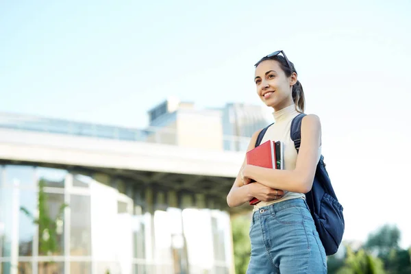 Bella donna felice con uno zaino che va al college. Giovane studentessa universitaria con libri nel campus . — Foto Stock