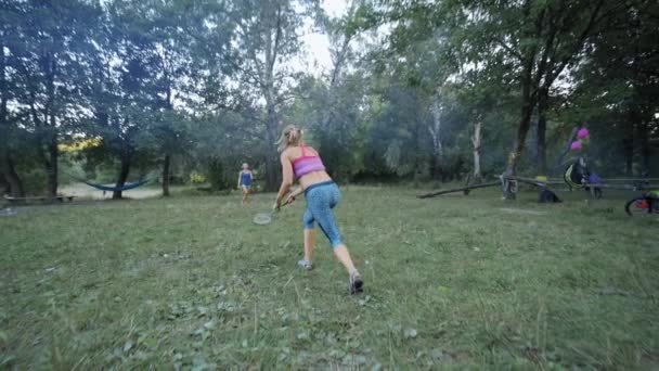 Muito desportivo fitness meninas estão jogando badminton no parque — Vídeo de Stock