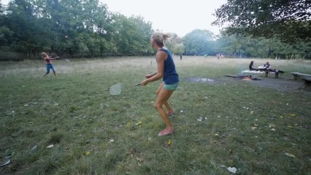 Bastante deportivo fitness Las niñas están jugando bádminton en el parque — Vídeo de stock